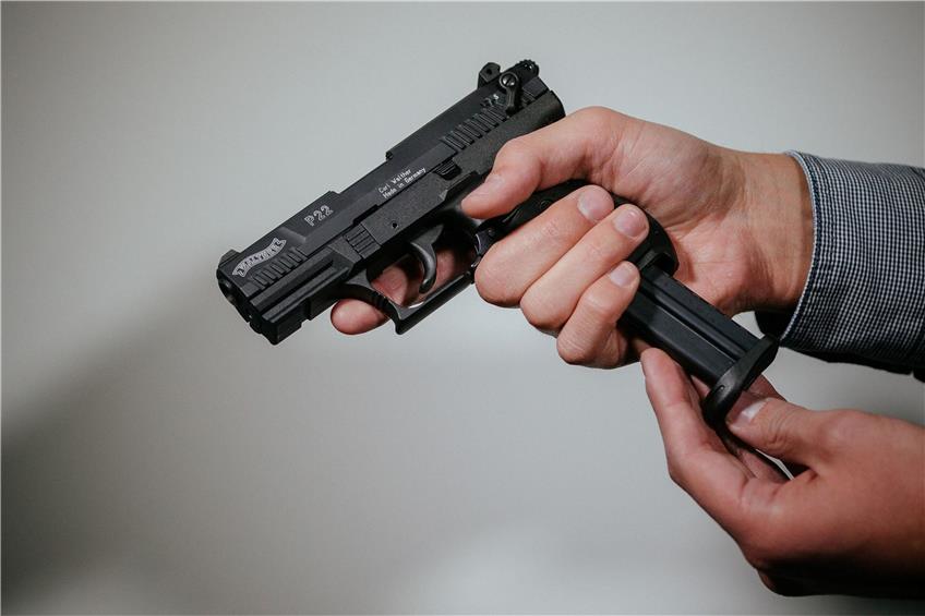 Ein Mann lädt eine Schreckschuss-Pistole „Walther P22“ mit einem Magazin. Foto: Oliver Killig/dpa-Zentralbild/dpa/Illustration