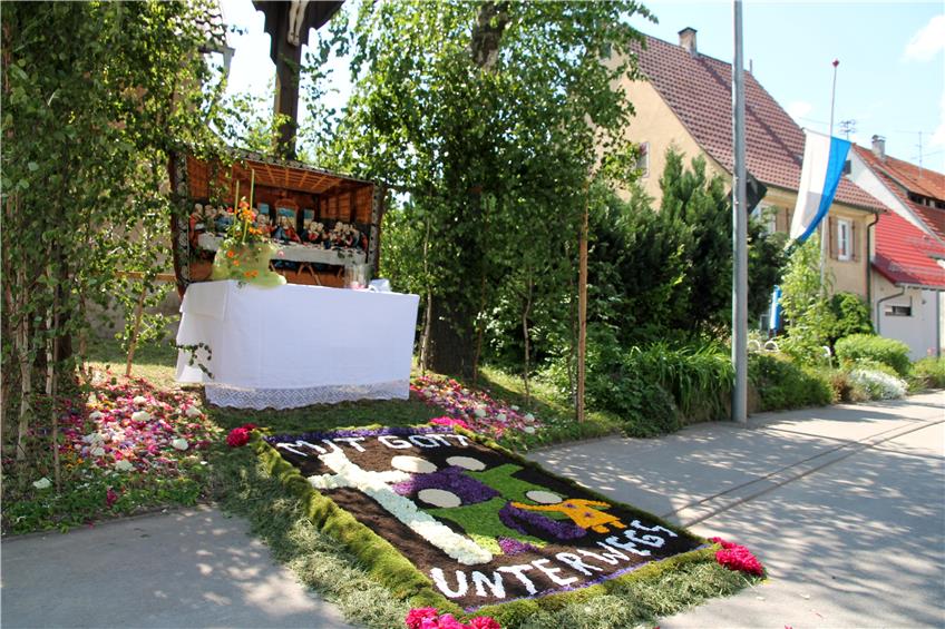 Ein geknüpfter Teppich mit Abendmahl hinter und ein Blütenteppich mit Motiv vor einem Altar in Hemmendorf. Bild: Fleischer