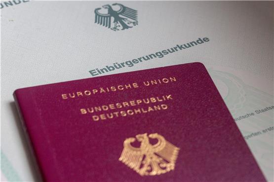 Eine Einbürgerungsurkunde der Bundesrepublik Deutschland und ein deutscher Reisepass liegen auf einem Tisch. Foto: Fernando Gutierrez-Juarez/dpa
