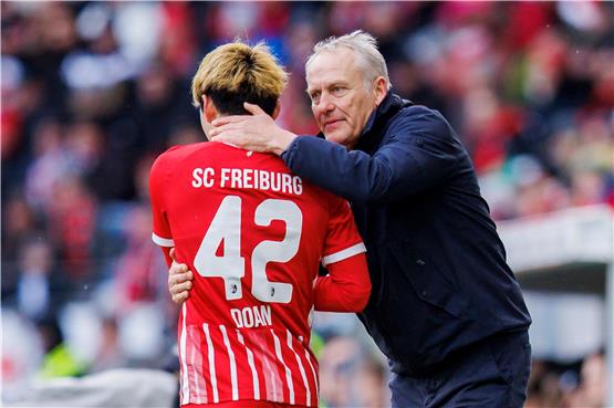 Freiburgs Trainer Christian Streich (r) spricht mit Freiburgs Ritsu Doan (l) nach seiner Auswechslung. Foto: Tom Weller/dpa