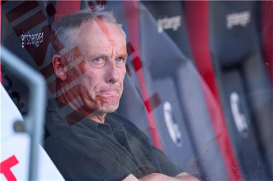 Freiburgs Trainer Christian Streich sitzt nach dem Spiel mit Tränen in den Augen auf der Ersatzbank. Foto: Tom Weller/dpa