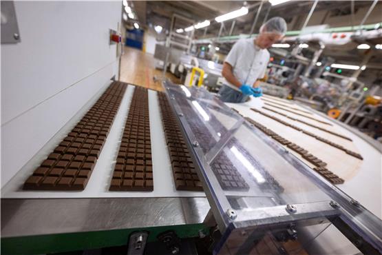 Schokoladentafeln liegen in der Produktion am Hauptsitz der Alfred Ritter GmbH & Co. KG, auf einem Laufband. Foto: Marijan Murat/dpa