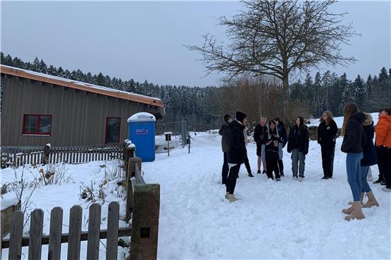 Anja Lewandowski (links, mit schwarzer Mütze) erläuterte den Jugendlichen, wie es zum Bau des Loßburger Waldkindergartens kam. Bild: Christiane Frey