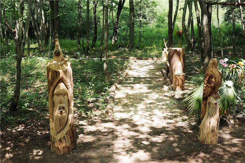 Aus Holz herausgesägte Figuren säumen den Weg in Sailes Waldpark.