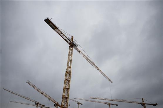 Baukräne vor grauem Himmel: In der Immobilienwirtschaft zeigen sich viele Zeichen einer Krise. Foto: Marijan Murat/dpa