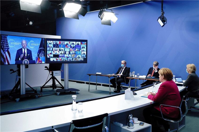 Bundeskanzlerin Angela Merkel (rechts) beim virtuellen Klimagipfel. Auf der Videowand spricht US-Präsident Joe Biden. Foto: Nestor Bachmann/dpa Foto: Nestor Bachmann/dpa