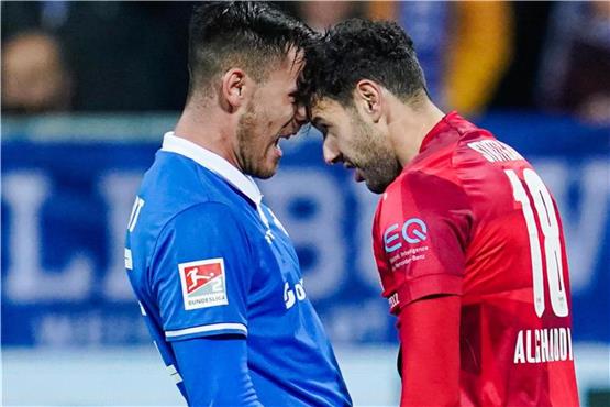 Darmstadts Dario Dumic (l) und Stuttgarts Hamadi Al Ghaddioui geraten während des Spiels aneinander. Foto: Uwe Anspach/dpa