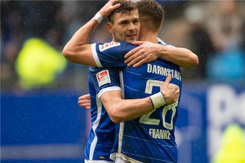 Darmstadts Mathias Wittek (l) und Marcel Franke umarmen sich nach dem Spiel. Foto: Axel Heimken/dpa/Archivbild