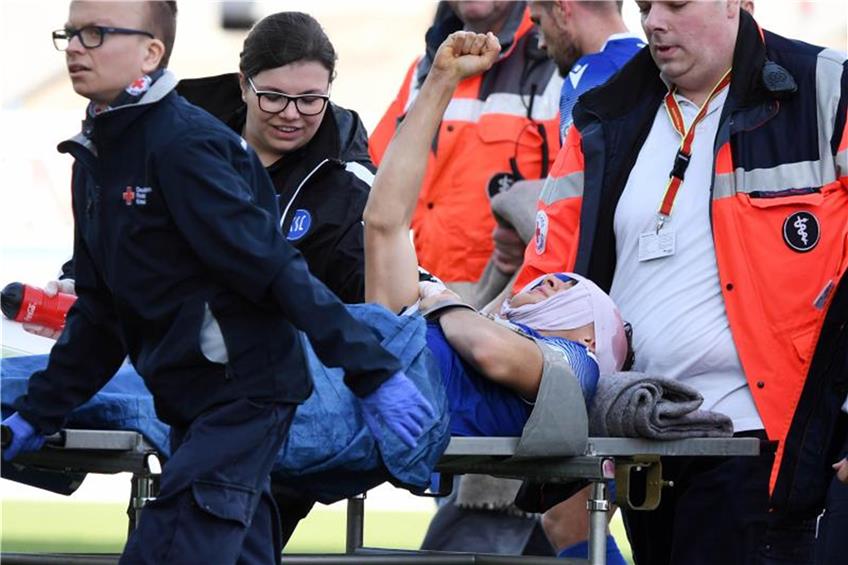 Der Fußballspieler Dirk Carlson vom Karlsruher SC wird verletzt vom Platz gebracht. Foto: Uli Deck/dpa