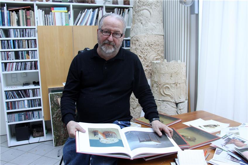 Der Künstler in seinem Glatter Atelierhaus: Norbert Stockhus blättert stolz in dem frischgedruckten opulenten „Bilder-Buch“. Bild: Priotto