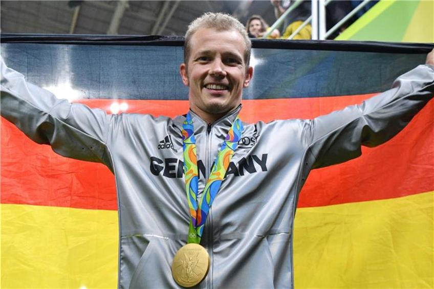 Der Reck-Olympiasieger Fabian Hambüchen hält die deutsche Fahne. Foto: Lukas Schulze/Archiv dpa/lhe