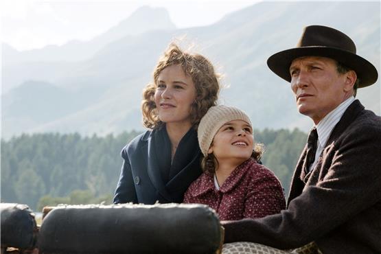 Die grandiose Schweizer Bergwelt ist nur die erste Station des Exils: Anna (Riva Krymalowski) mit ihren Eltern (gespielt von Carla Juri und Oliver Masucci). Bild: Warner Bros. GmbH