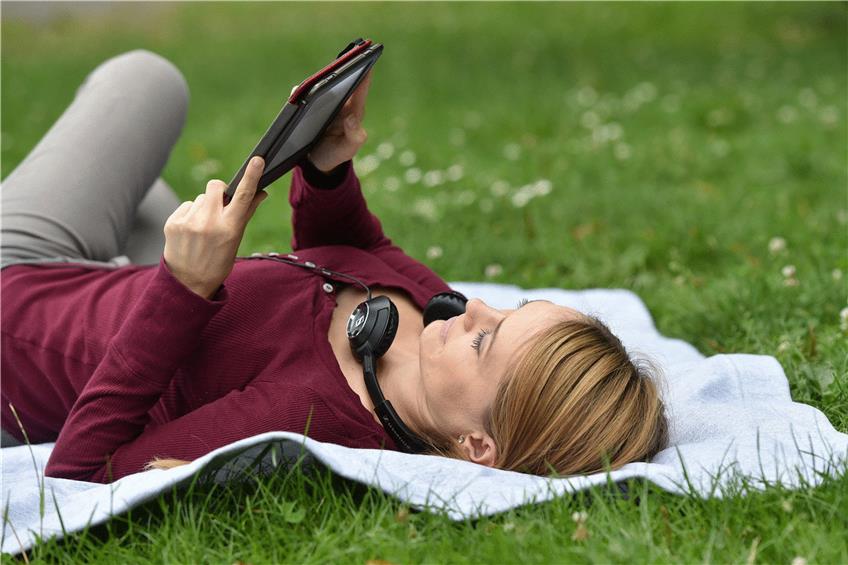 E-Book-Reader lassen sich auch im Freien und bei vollem Sonnenlicht gut bedienen. Foto: Jens Kalaene/dpa