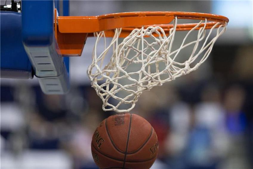 Ein Basketball fällt durch das Netz vom Basketballkorb. Foto: Lukas Schulze/Archiv dpa