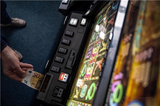 Ein Geldschein wird in einen Fun-Game-Automat geschoben. Foto: Bernd Thissen/dpa