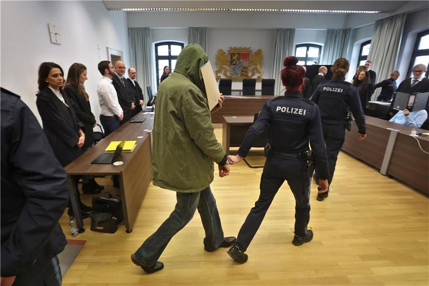 Ein Mann (M) wird im Landgericht in einen Gerichtssaal geführt. Er wird gemeinsam mit seiner Frau des Doppelmordes beschuldigt. Foto: Karl-Josef Hildenbrand/dpa