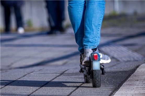 Ein Mann fährt mit einem E-Scooter. Foto: Jens Büttner/dpa