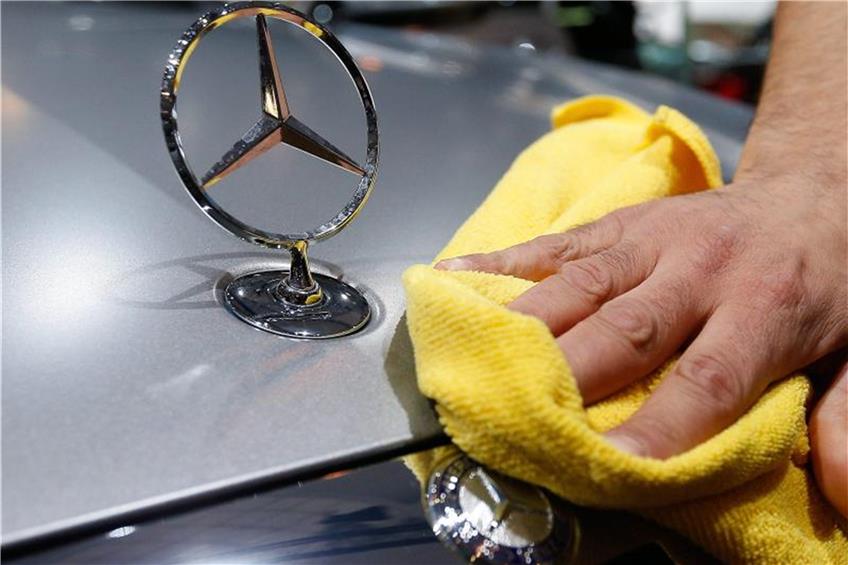 Ein Mann poliert einen Mercedes. Foto: Laurent Dubrule/Archiv dpa