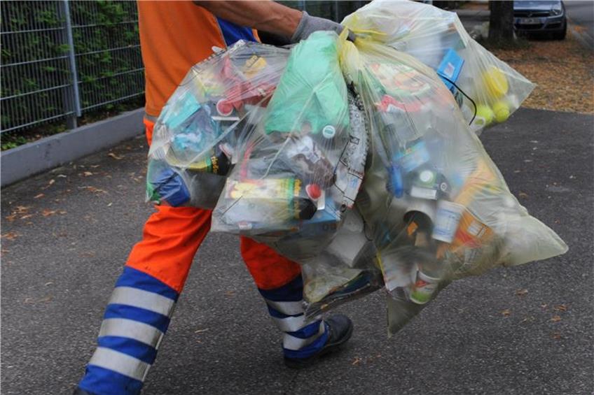 Ein Mitarbeiter der Abfallwirtschaft und Stadtreinigung bringt gelbe Säcke zum Müllwagen. Foto: Patrick Seeger/Archiv dpa/lsw