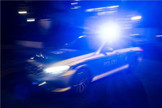 Ein Polizeifahrzeug fährt mit Blaulicht an einem Gebäude vorbei. Foto: Marijan Murat/dpa/Symbolbild