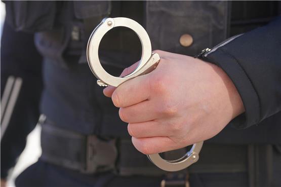 Ein Polizist hält Handschellen in der Hand. Foto: Marcus Brandt/dpa/Symbolbild