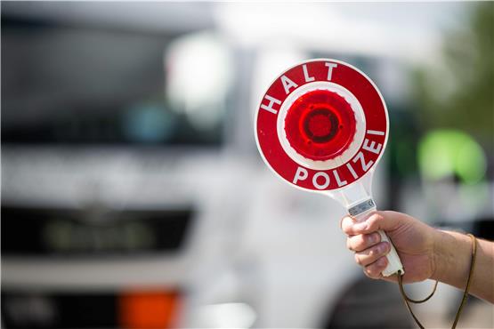 Ein Polizist hält bei einer Verkehrskontrolle eine Polizeikelle in der Hand. Foto: Jonas Güttler/dpa/Symbolbild