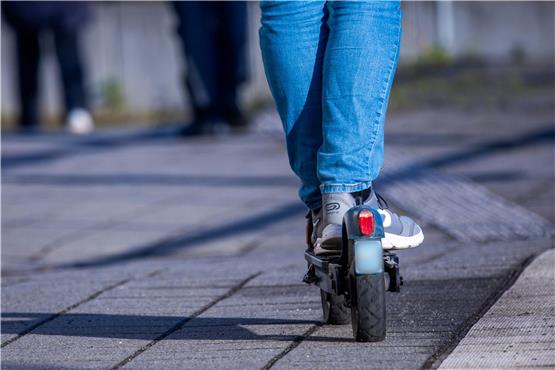 Ein Reisender fährt mit seinem E-Scooter über den Bahnsteig. Foto: Jens Büttner/dpa/Symbolbild