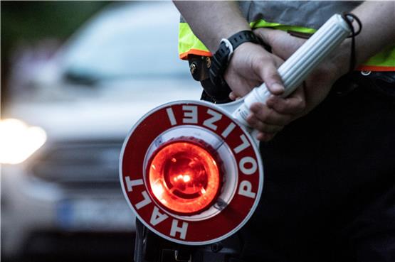 Ein Polizist hält bei einer Verkehrskontrolle eine Winkerkelle in der Hand. Foto: Paul Zinken/dpa/ZB/Symbolbild