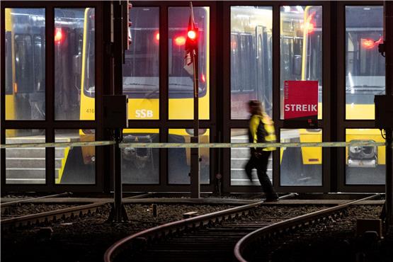 Eine Teilnehmerin an einem Warnstreik geht an einem Stadtbahndepot der Stuttgarter Straßenbahnen AG (SSB) vorbei. Foto: Marijan Murat/dpa