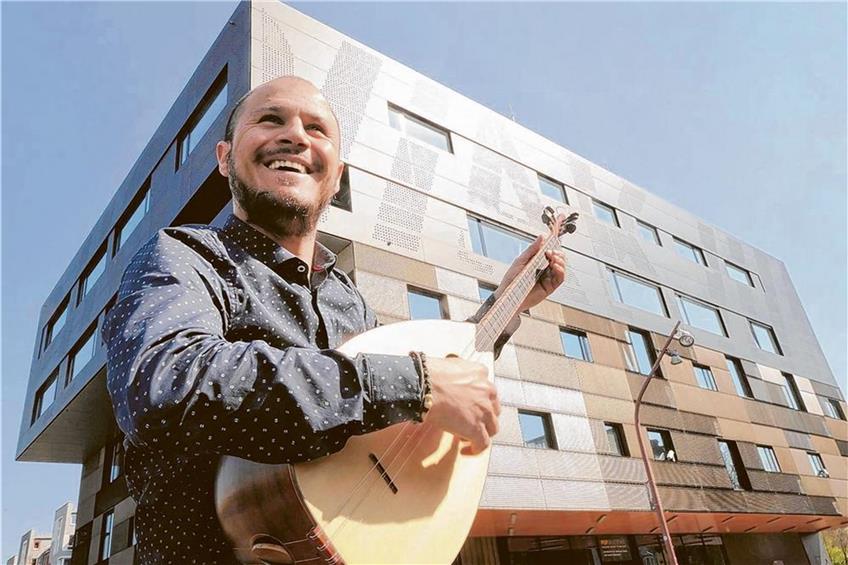 Er studiert in Mannheim Weltmusik: Turgut Keskin mit seiner Baglama vor der Popakademie. Foto: epd