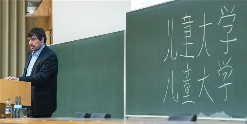 „Értóng dàxué“: So heißt Kinder-Uni auf chinesisch. Die Schriftzeichen dafür schrieb Matthias Niedenführ an die Tafel im Hörsaal. Bild: Metz