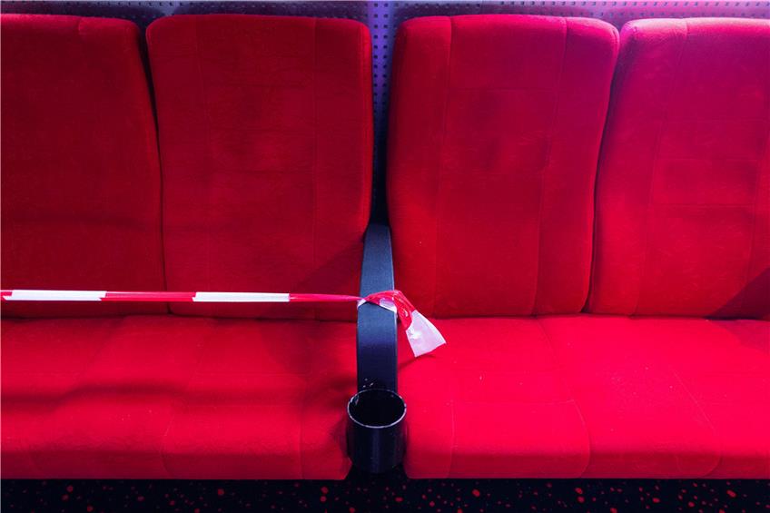 Flatterbänder zeigen, welche Plätze im Kinosaal leer bleiben müssen. Foto: Robert Michael/dpa-Zentralbild/dpa
