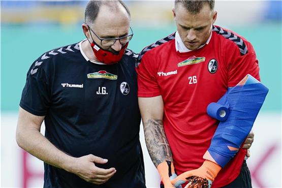 Freiburgs Torwart Mark Flekken geht vor Spielbeginn verletzt vom Spielfeld. Foto: Uwe Anspach/dpa/Aktuell