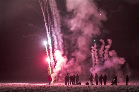 Größer ja, teurer auch – aber weniger Kracher als früher: Tübinger beim Silvester-Feuerwerk auf einer Wiese bei Weilheim. Bild: Ulrich Metz