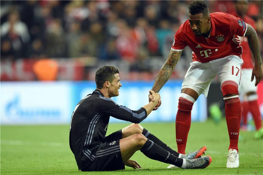 Hier hilft Jérôme Boateng (rechts) Cristiano Ronaldo auf die Beine. In Madrid droht der Weltmeister verletzt auszufallen. Foto: dpa