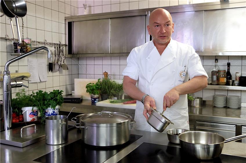 Hinter dem Induktionsherd steht „Warteck“-Küchenchef Oliver Gläßel für kulinarische Oster-Genüsse mit Töpfen und Rührlöffel bereit Bilder: Kuball