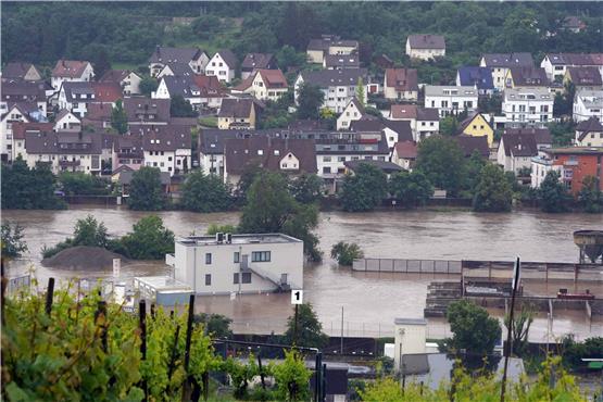 In Benningen am Neckar im Landkreis Ludwigsburg stehen Gebäude im Hochwasser des Neckars, der hier über die Ufer getreten ist. Foto: Andreas Rosar/dpa