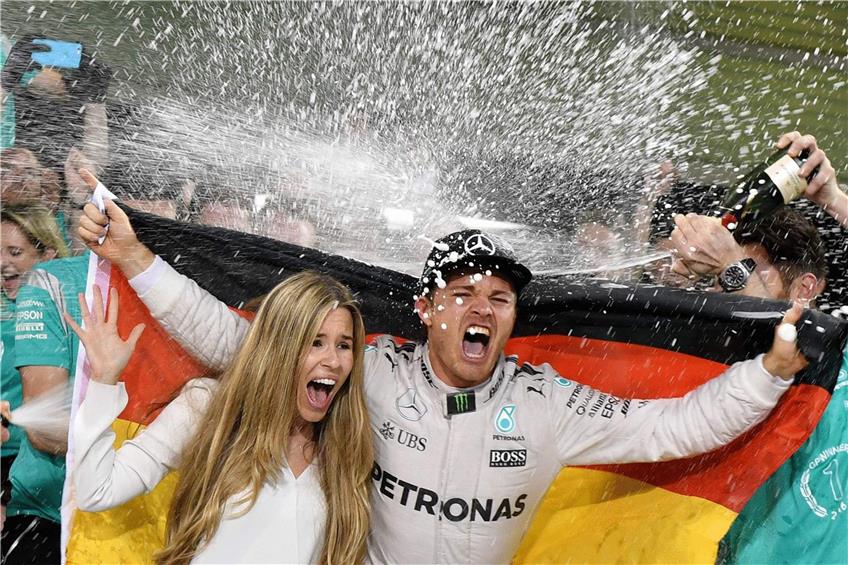 In Partylaune: Nico Rosberg nimmt mit seiner Frau Vivian die klebrig feuchte Champagner-Dusche. Foto: AFP
