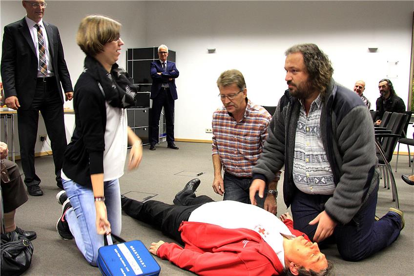 Jenny Kreher, Helmut Mutschler, Edwin Bailer, und Urban Kreher (liegend) demonstrieren den Einsatz eines Defibrillators. Bild: kpd