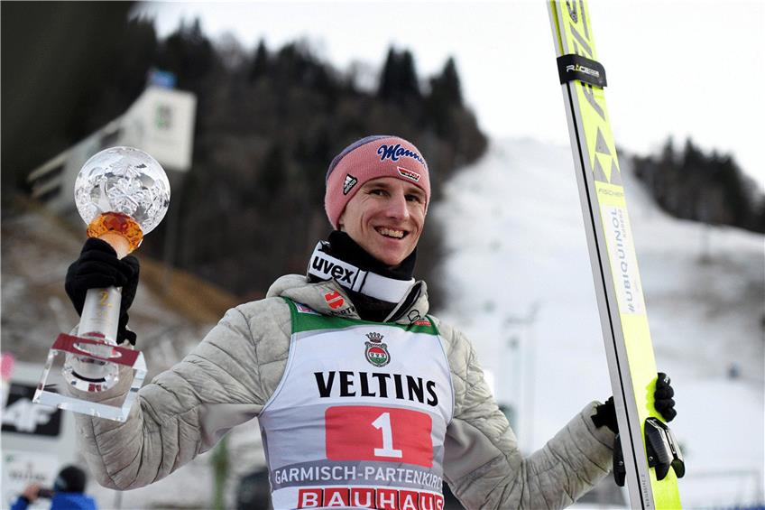 Karl Geiger, Skispringer aus Deutschland, jubelt über seinen zweiten Platz mit Pokal nach der Siegerehrung. Foto: Angelika Warmuth/dpa