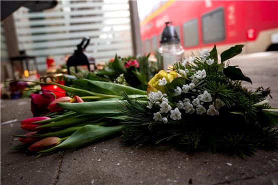 Kerzen und Blumen stehen und liegen am Freitag im Bahnhof Brokstedt in einem Wartehäuschen.   Foto: Daniel Bockwoldt/dpa