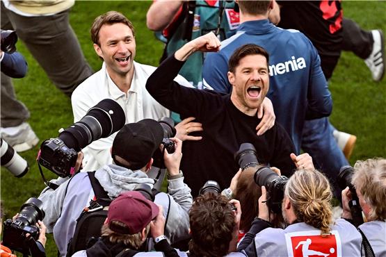 Leverkusens Trainer Xabi Alonso (r) und Sportchef Simon Rolfes jubeln über den Gewinn der Deutschen Meisterschaft. Foto: David Inderlied/dpa