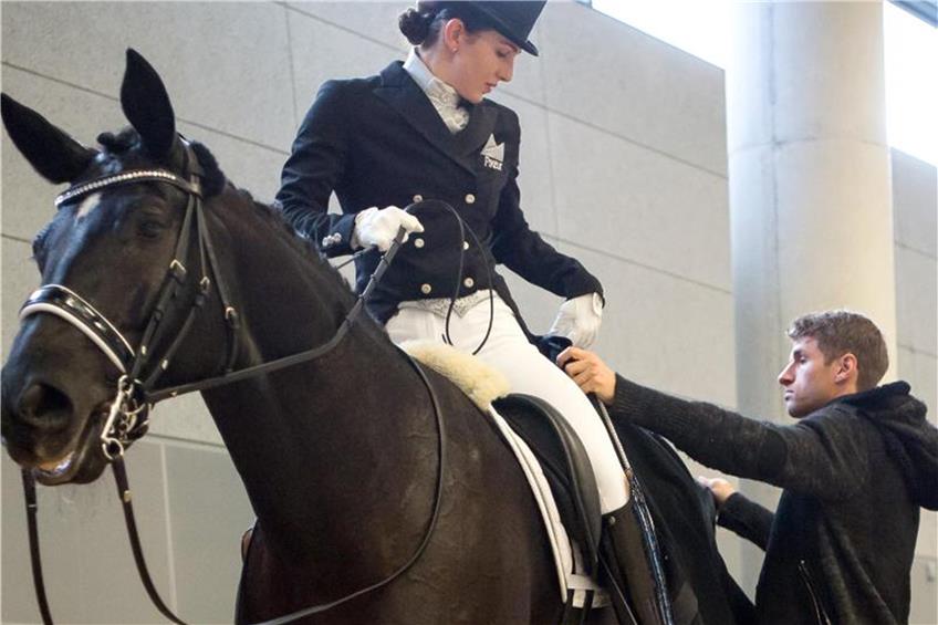 Lisa Müller steht mit ihrem Pferd in der Abreithalle. Foto: Peter Kneffel/dpa