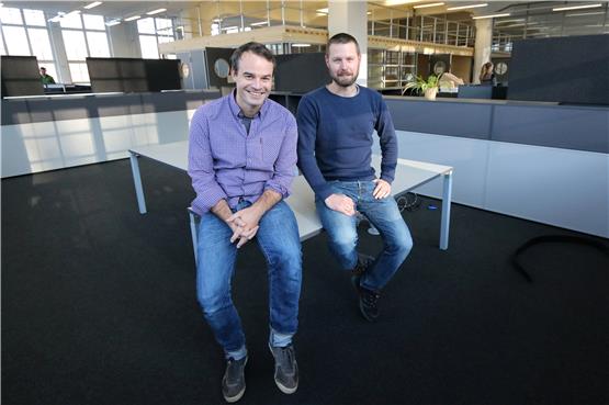 Matthais Gebhard (links) und Ronny Höhn am neuen, noch nicht eingerichteten Arbeitsplatz im Großraumbüro. Im Hintergrund das Raum-in-Raum-System. Bild: Hantke