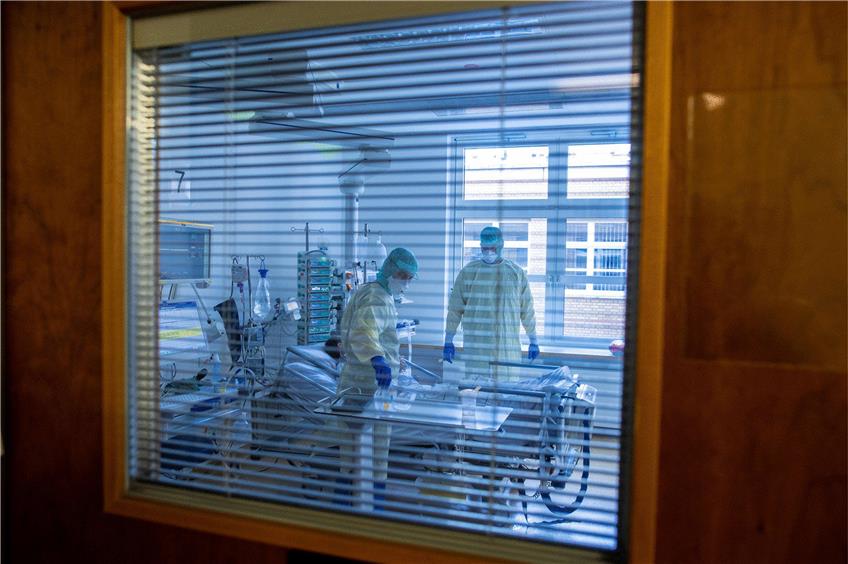 Mediziner und Pfleger versorgen einen an Covid-19 erkrankten Patienten in der Universitätsklinik Greifswald. Foto: Jens Büttner/dpa