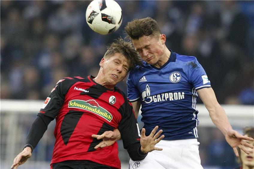 Mike Frantz (links) im Kopfballduell mit Schalkes Fabian Reese. Foto: Roland Weihrauch dpa