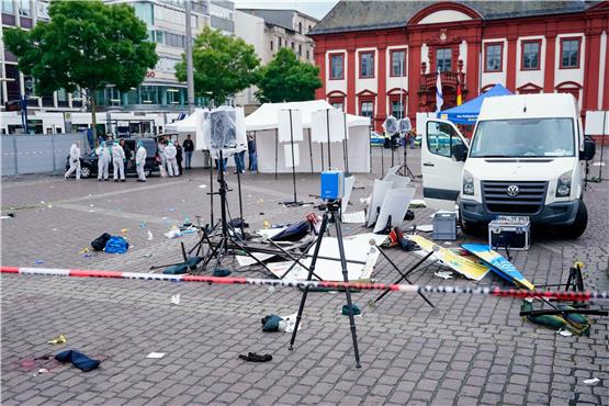 Mitarbeiter der Spurensicherung stehen auf dem Marktplatz hinter einem zertrümmerten Stand. Foto: Uwe Anspach/dpa