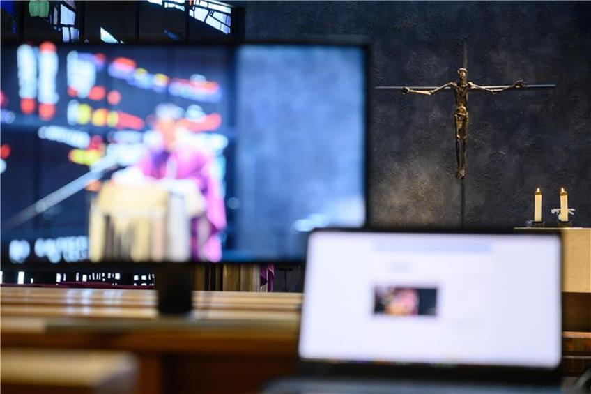 Monitore stehen in einer leeren Kirche während eines Gottesdiensts. Foto: Sebastian Gollnow/dpa