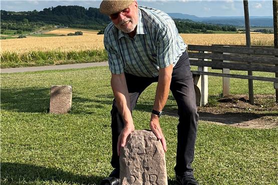 Ortshistoriker Reinhold Bauer mit einem Stein für den Grenzsteinpark, der noch mit einem Sockel versehen und dann gesetzt wird. In der Mitte ist schwach ein Abtsstab erkennbar. Bild: Andreas Straub