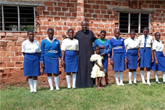 Pfarrer Gerald Wamala mit seinen Schülerinnen in Uganda , die auf Patenschaften aus dem Gäu hoffen.Privatbild